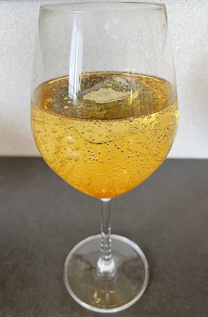 梅シロップをワイングラスに注ぎ、炭酸水で割った