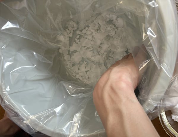 保存容器に漬物袋をかぶせ、粗塩を敷く