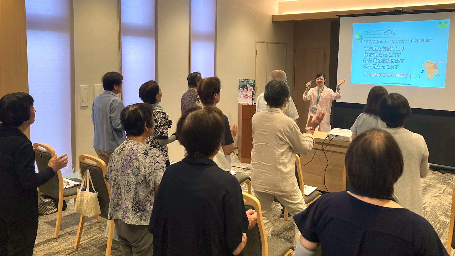 杏林堂薬局では、地域の認知症を減らすことを目的に、健康セミナーを実施しています。2026年8月26日(水)には「軽度認知障害(MCI)啓もうセミナー」を「パルモ葬祭かぞくホール堀越」にて実施しました。参加者の皆さんと一緒に学びながら、それと併せて頭と体を同時に使う「コンランじゃんけん」や「コグニサイズ」を行いました。