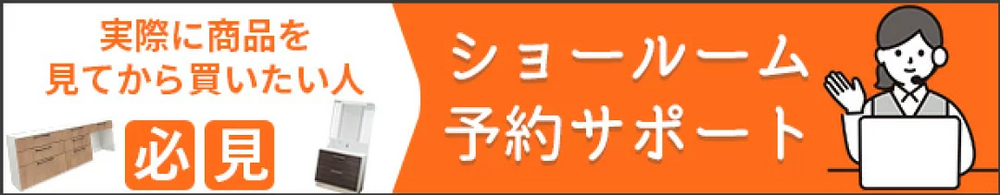 白背景に「実際に商品を見てから買いたい人」の文字とオレンジ色の「必見」の文字、木目調のキッチン家具と白い洗面台のイラストが並び、右側のオレンジ背景には「ショールーム予約サポート」の白文字と、ヘッドセットを着けノートパソコンを操作する女性スタッフのイラストが描かれたバナー画像。