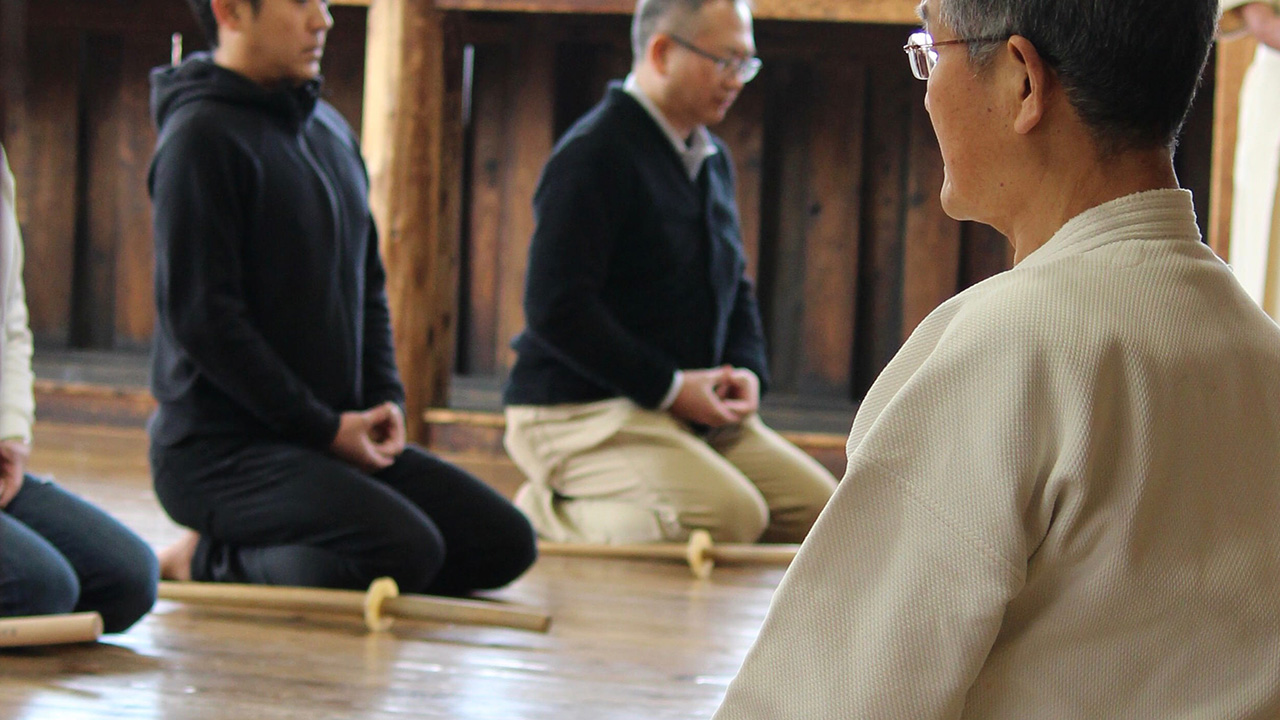 Business professionals learning alongside a traditional martial arts/dojo instructor.