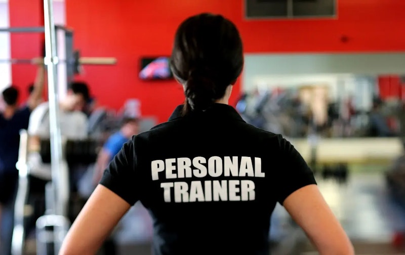 Personal trainer guiding a beginner client during a session, representing how to choose the right trainer