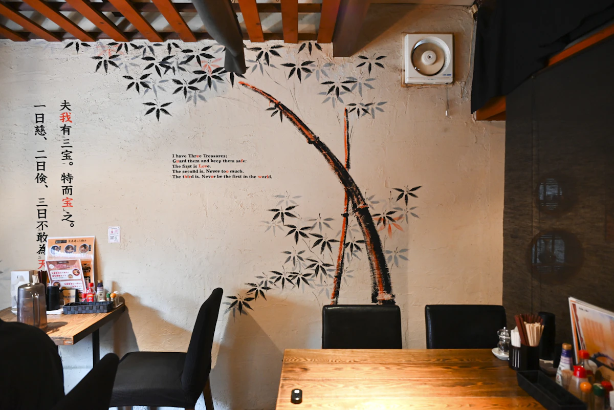 佐藤さんが最初に描いた壁画。お店のリクエストで、老子の道（タオ）から引用した言葉に、蒔絵の竹を組み合わせてデザインした。<br>場所：「生姜醤油らーめんと餃子の店 笑美寿と三椒」