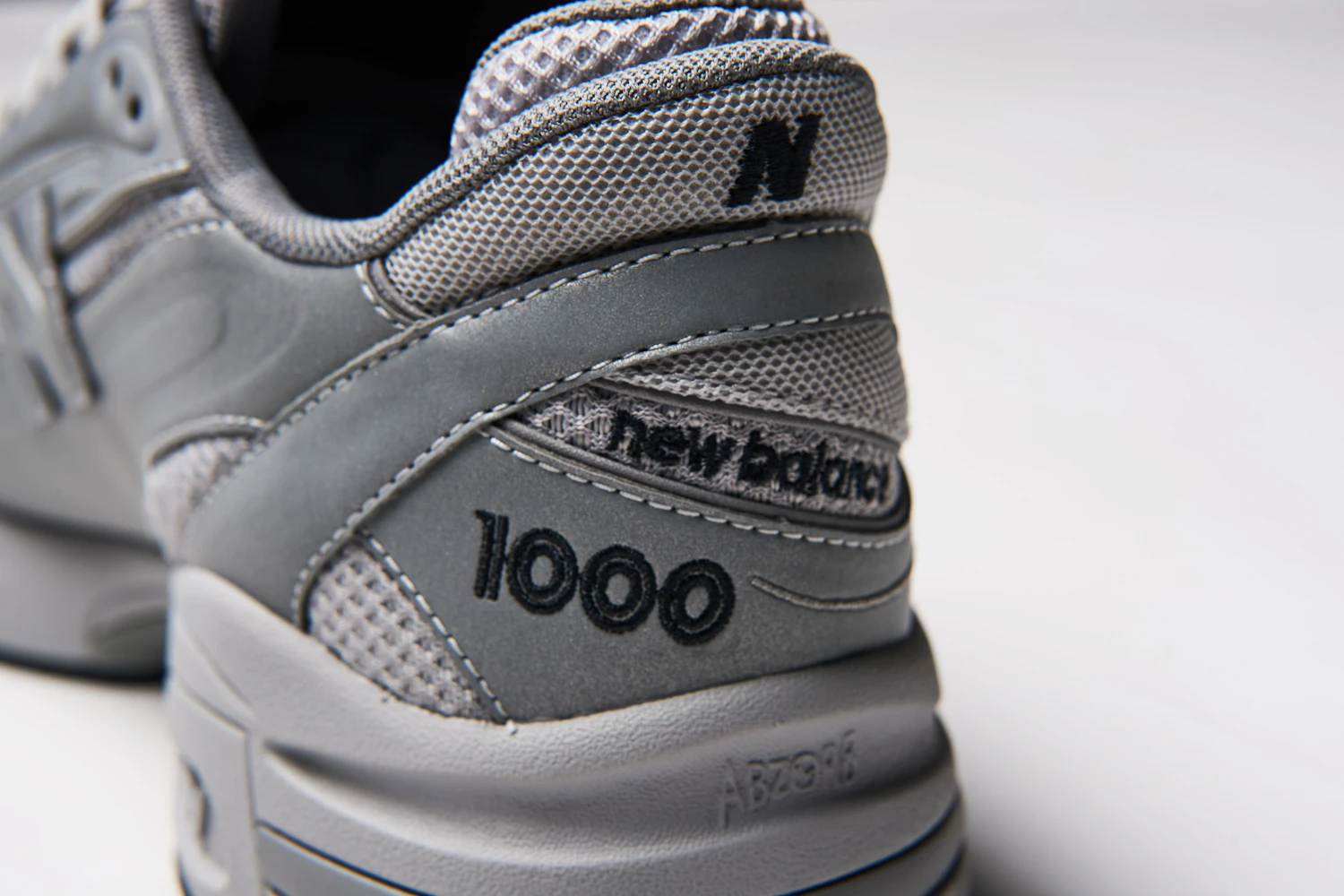 The heel features an embroidery of the model number "1000." Additionally, the midsole incorporates the brand's unique technology, "ABZORB."