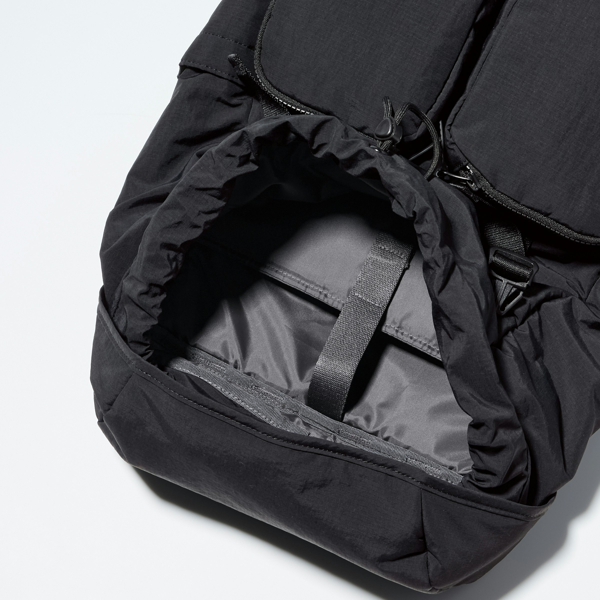 メイン収納にはPCスリーブスペースを確保し、巾着部分の紐はアジャスターによってまとめることができる