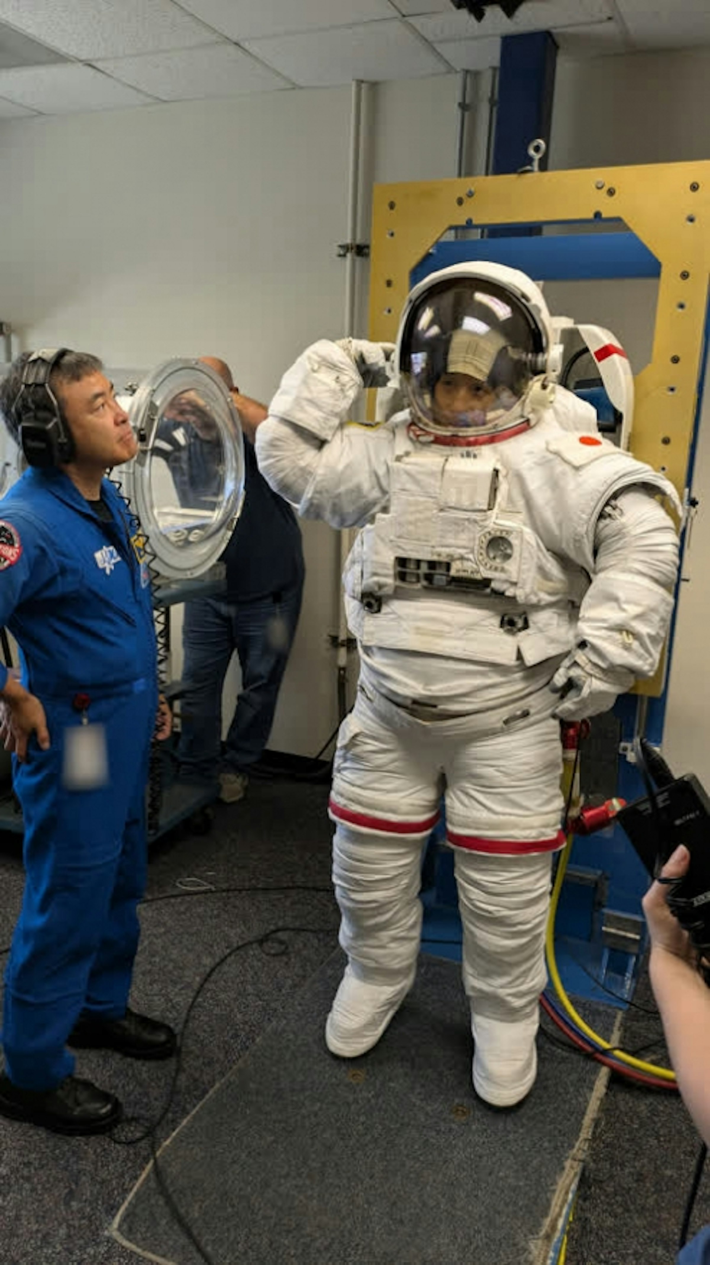 船外活動ユニット（EMU）のフィットチェックを行う米田宇宙飛行士候補者と見守る星出宇宙飛行士（©JAXA）