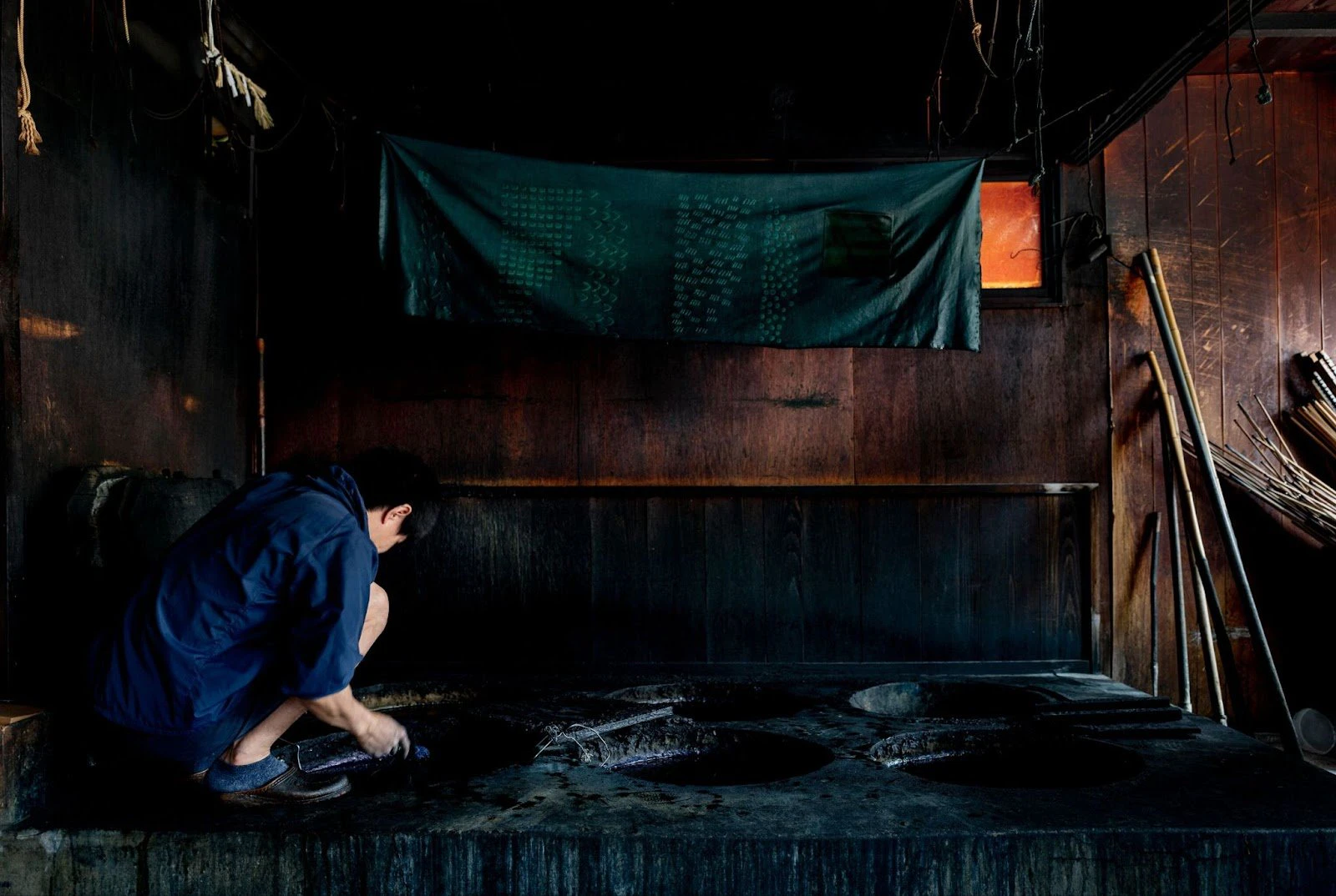 A dyeing room with six indigo vats embedded in the ground