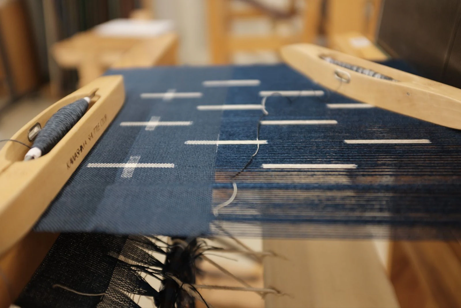 The kasuri weaving process, where dyed warp meets dyed weft to form precise patterns. Photo credit – Hannah Waldron