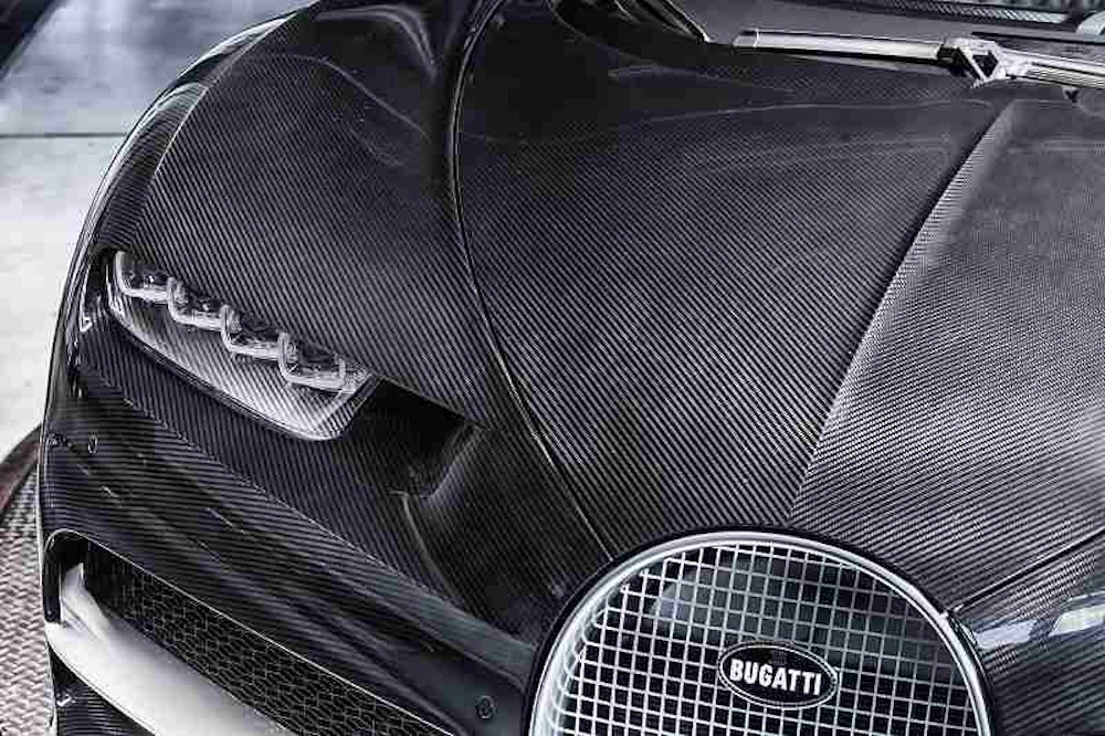 <p>エレガンス仕様はシャイニーカーボンファイバーボディを採用。純銀製のブガッティエンブレムにブラックエナメルを施し、漆黒の美しさを際立たせる。</p>