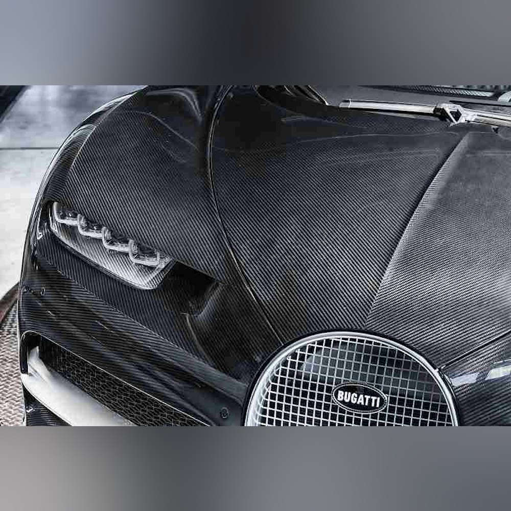 <p>エレガンス仕様はシャイニーカーボンファイバーボディを採用。純銀製のブガッティエンブレムにブラックエナメルを施し、漆黒の美しさを際立たせる。</p>