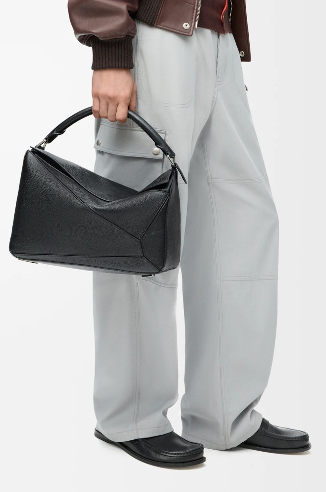 <p>パズルバッグは、折り紙から着想を得た独特のデザインが特徴。精確なカッティング技術により、幾何学的なラインと四方体のフォルムを実現。</p>