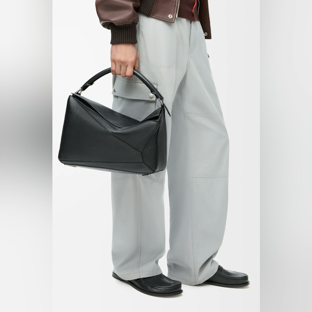 <p>パズルバッグは、折り紙から着想を得た独特のデザインが特徴。精確なカッティング技術により、幾何学的なラインと四方体のフォルムを実現。</p>