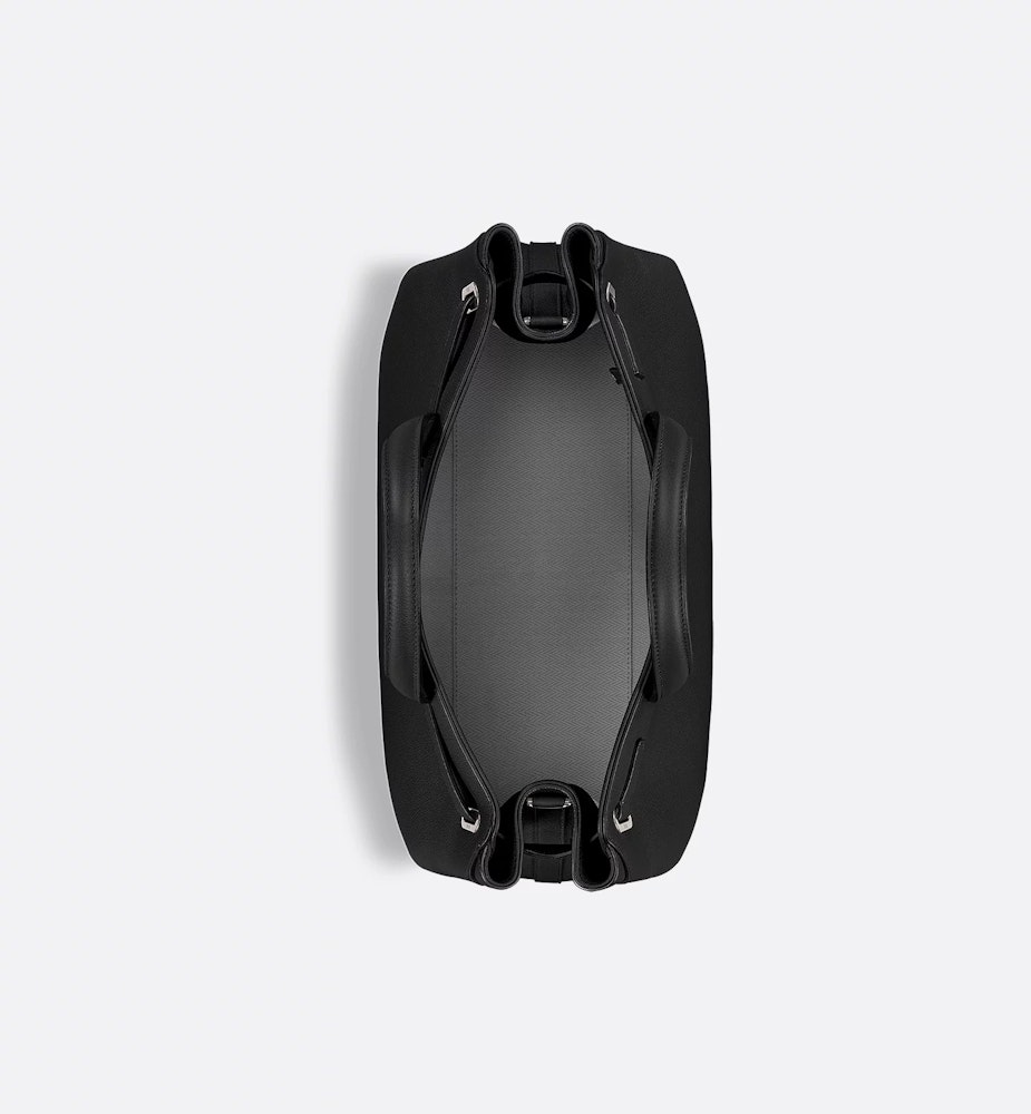 <p>サイドのグラフィカルな構造、Diorシグネチャー入りの底鋲、クッション入りのトップハンドルなど、精緻なディテールが特徴。内側にはスリップポケット2つとジップポケット1つを備え、ヘリンボーンモチーフの裏地を施している。</p>