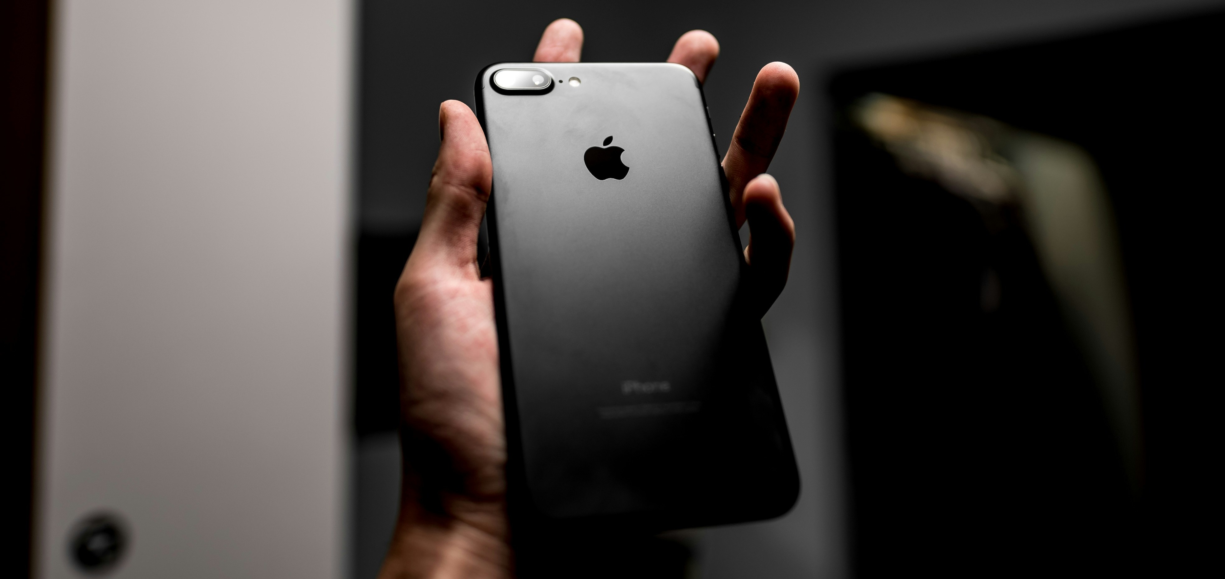 ホームボタン付きiPhoneを手に持ったシーン