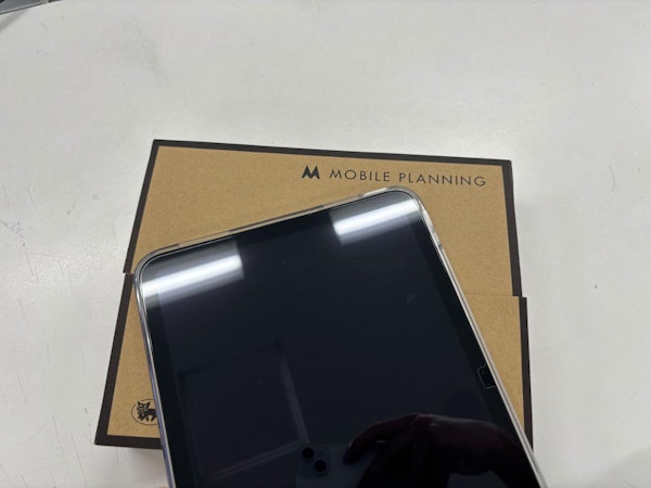 キッティング（初期設定）が完了したiPadを、お客様の元へ安全にお届けするためにダンボールへ丁寧に梱包している出荷準備の様子