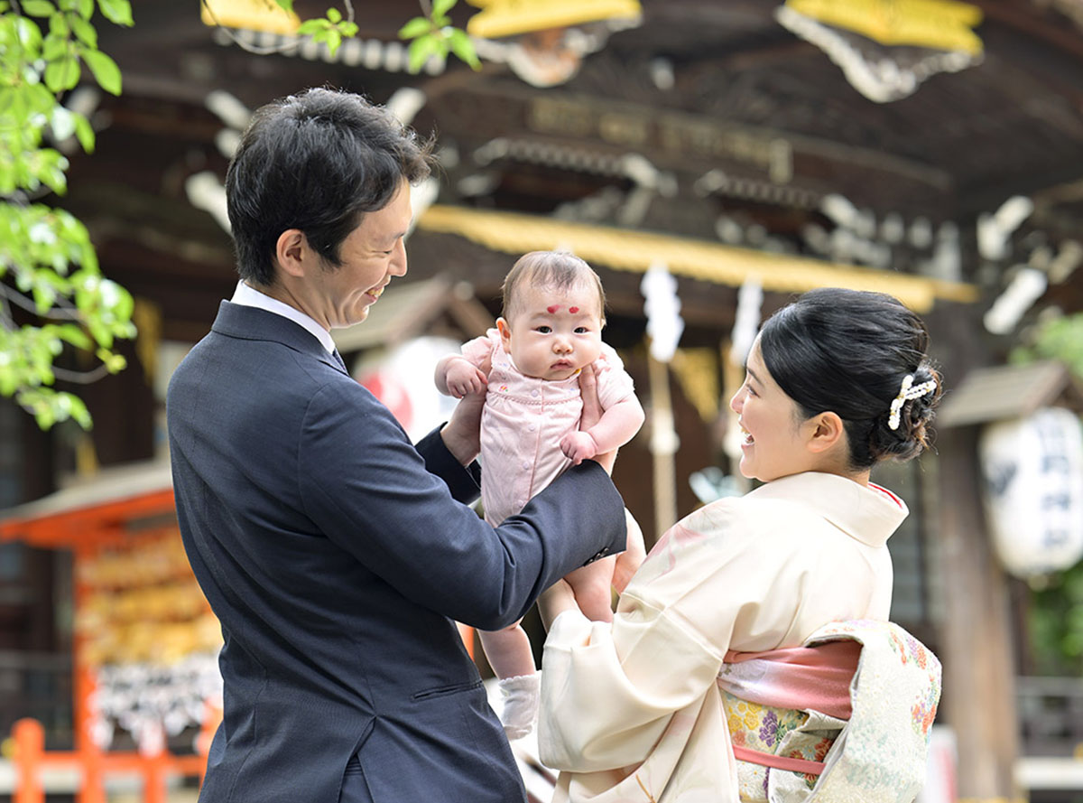 本殿を背景にしたお宮参り家族写真