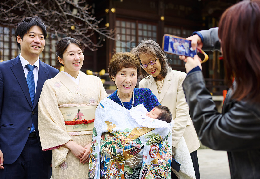 赤ちゃんを抱っこする祖父母の笑顔