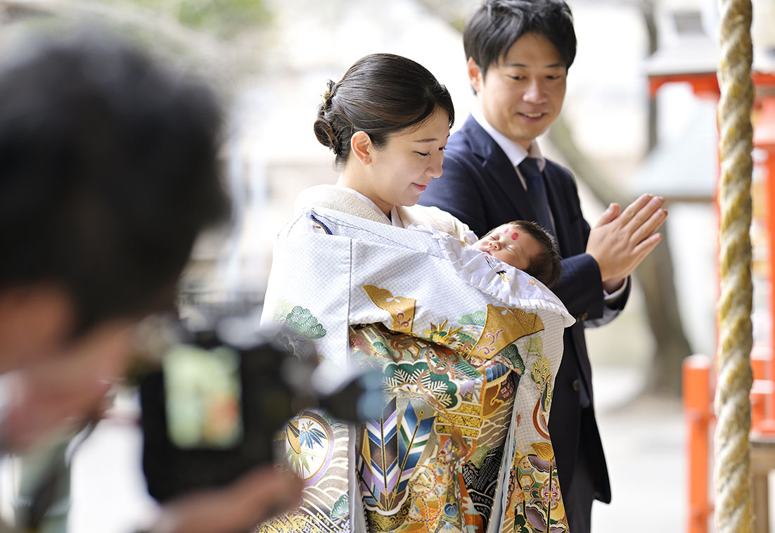 新宿十二社熊野神社でお参りをするお宮参りの家族