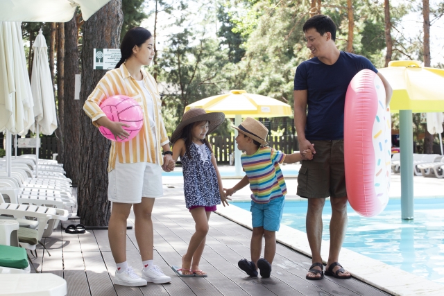プールサイドを歩く家族