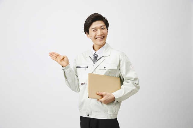 笑顔で右手を挙げて促すポーズをとる施工業者の男性