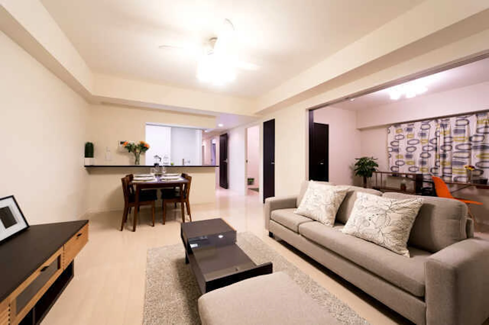 ベージュ系のクロス、フロアにグレー系の家具がアクセントとなったリビングダイニング