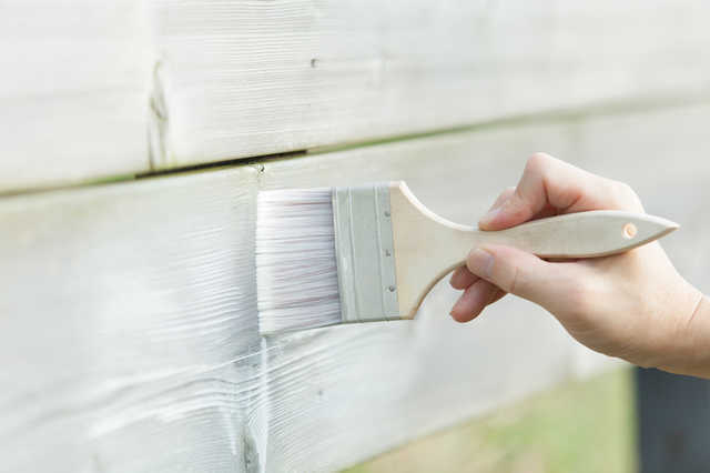 木材を刷毛で塗装する様子