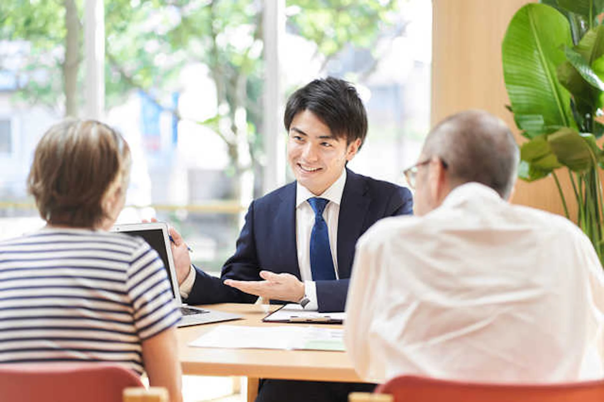 老夫婦と、スーツを着た笑顔の男性