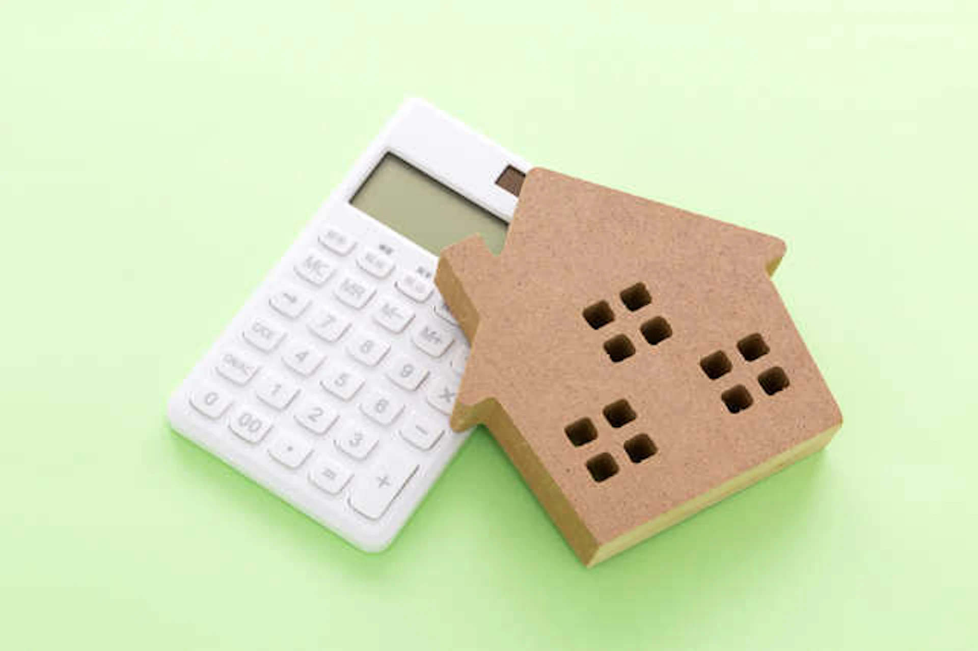 電卓と木でできた家型のオブジェ