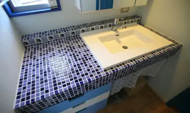 青いタイルが印象的な洗面スペース