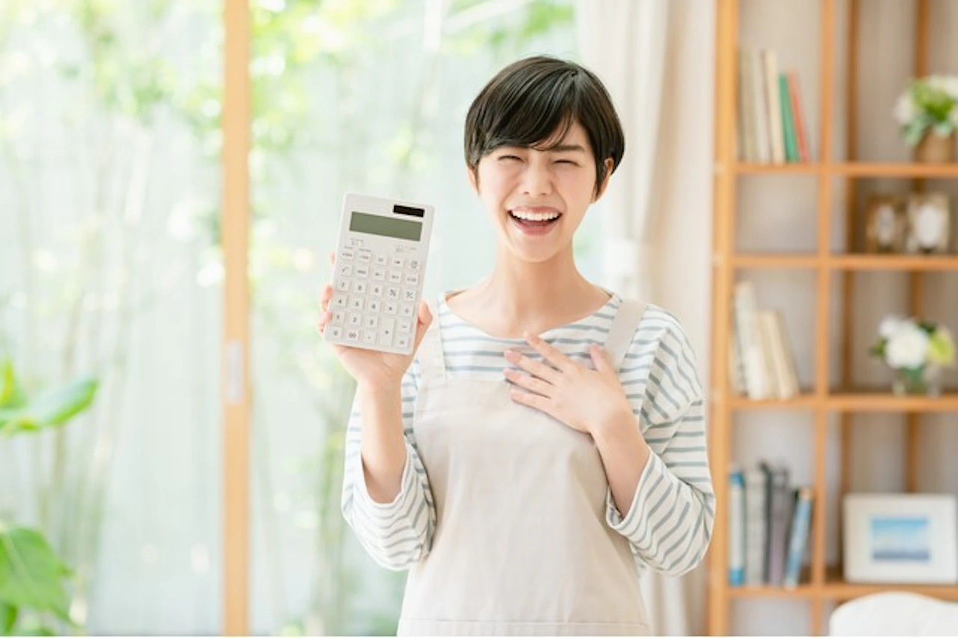 電卓片手に笑う女性