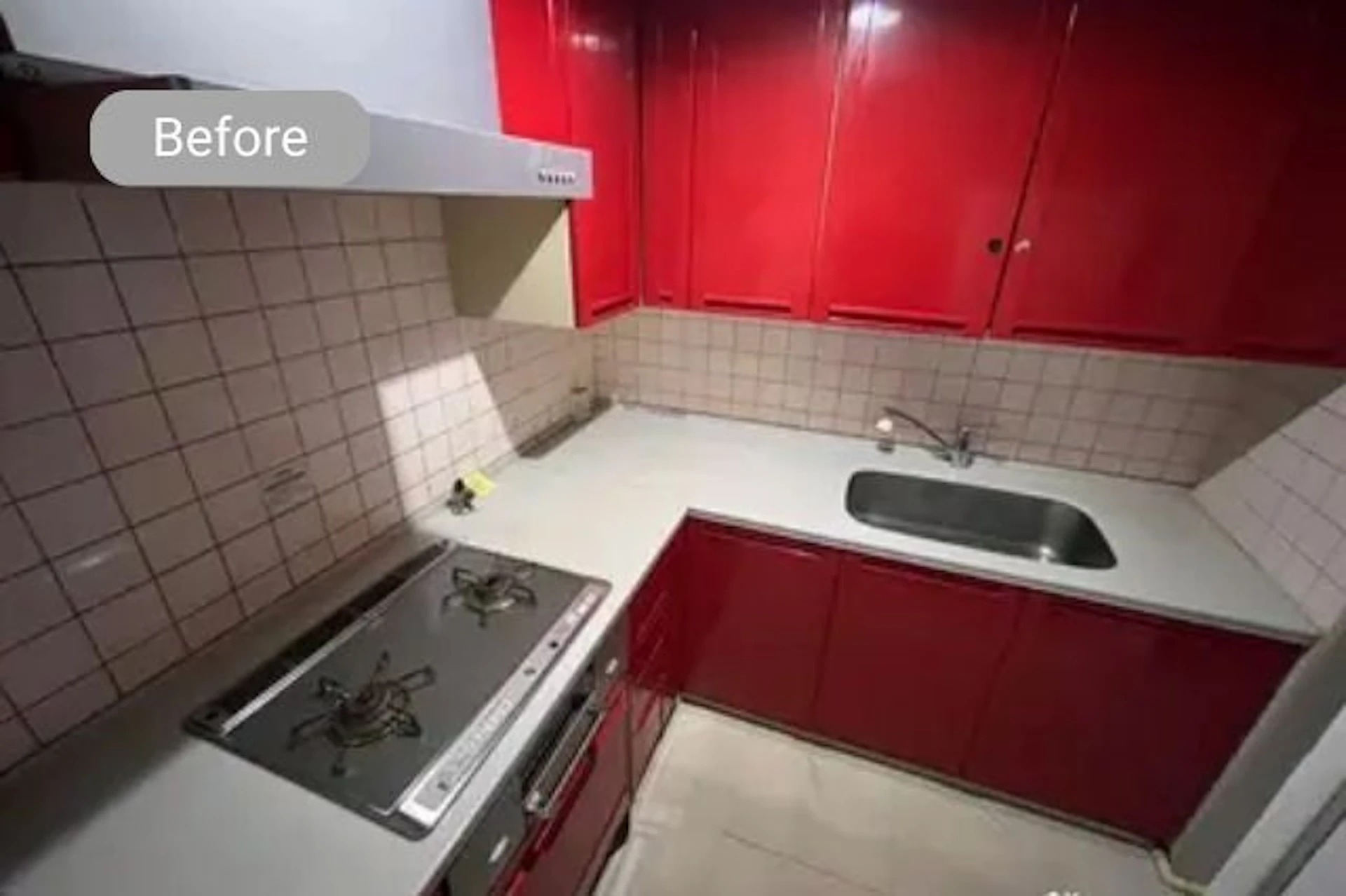 赤と白基調のL型キッチンをリフォームする前の写真