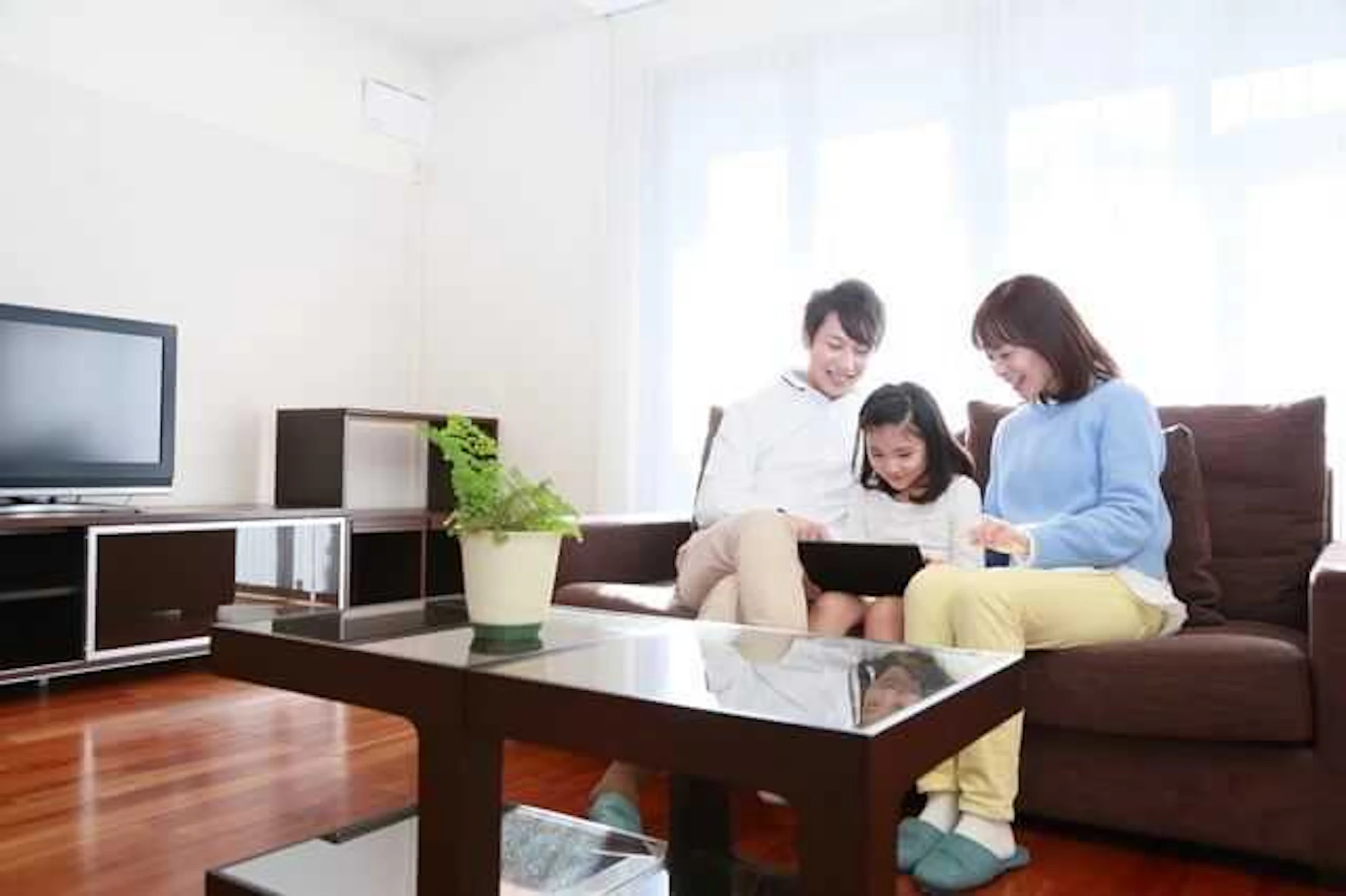 リビングのソファに座ってくつろぐ親子
