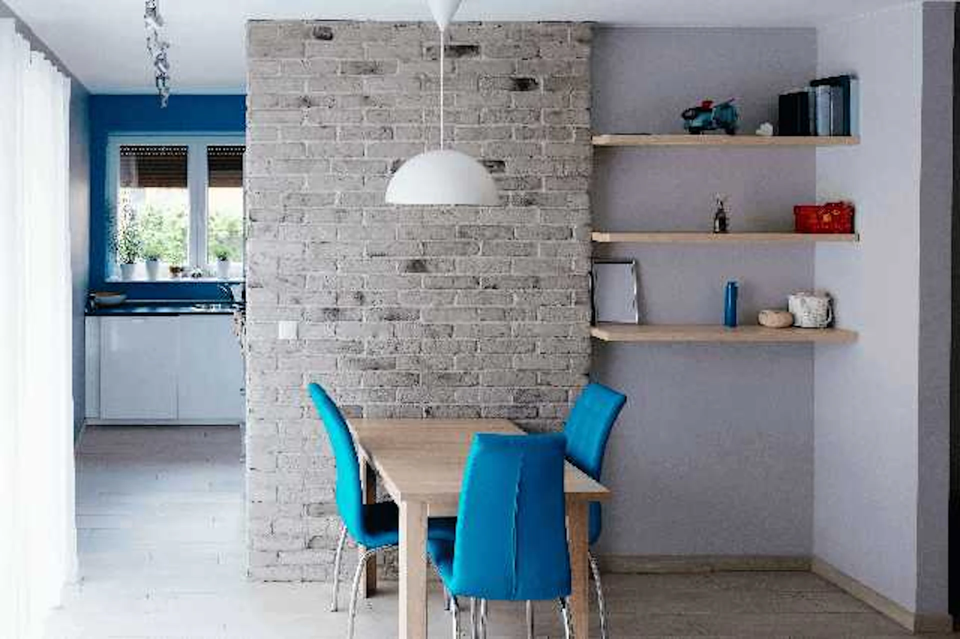 淡いグレー系のレンガ調クロスをアクセントとしたダイニング ダイニングチェアはターコイズブルー