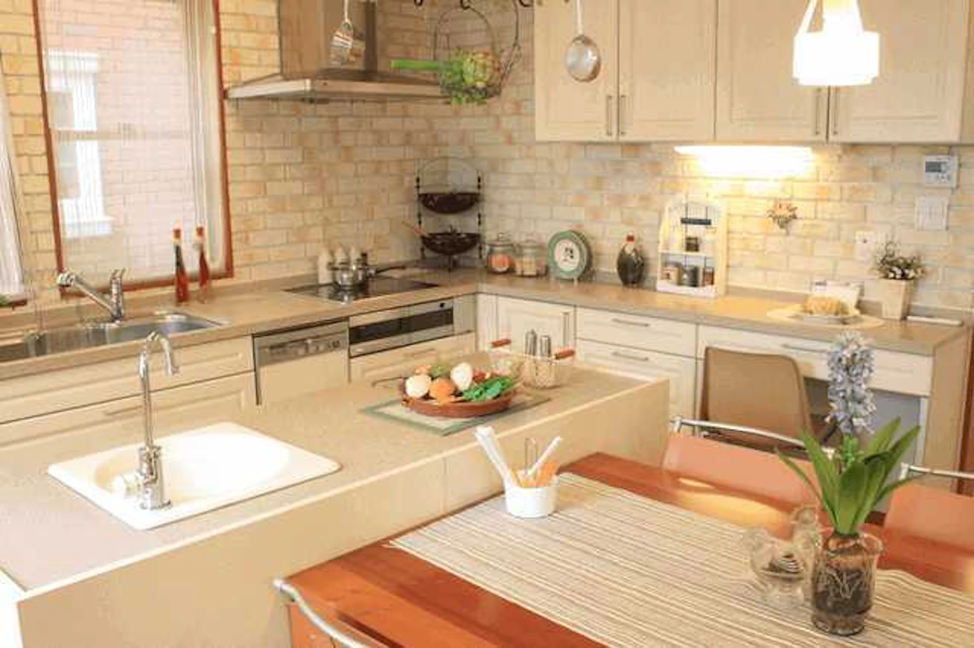 白とベージュで統一された西洋風のL型キッチンの写真