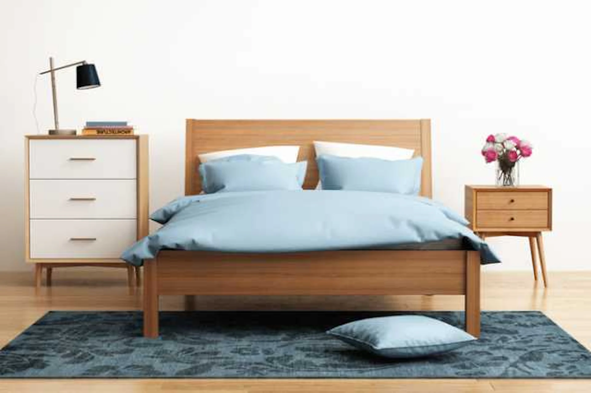 木目調のベッドにペールブルーのベッドカバーと枕