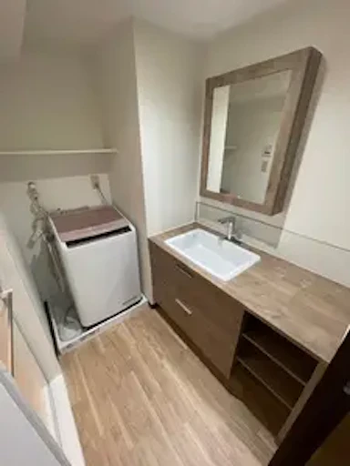 ナチュラルな優しい色合いの洗面脱衣所へ