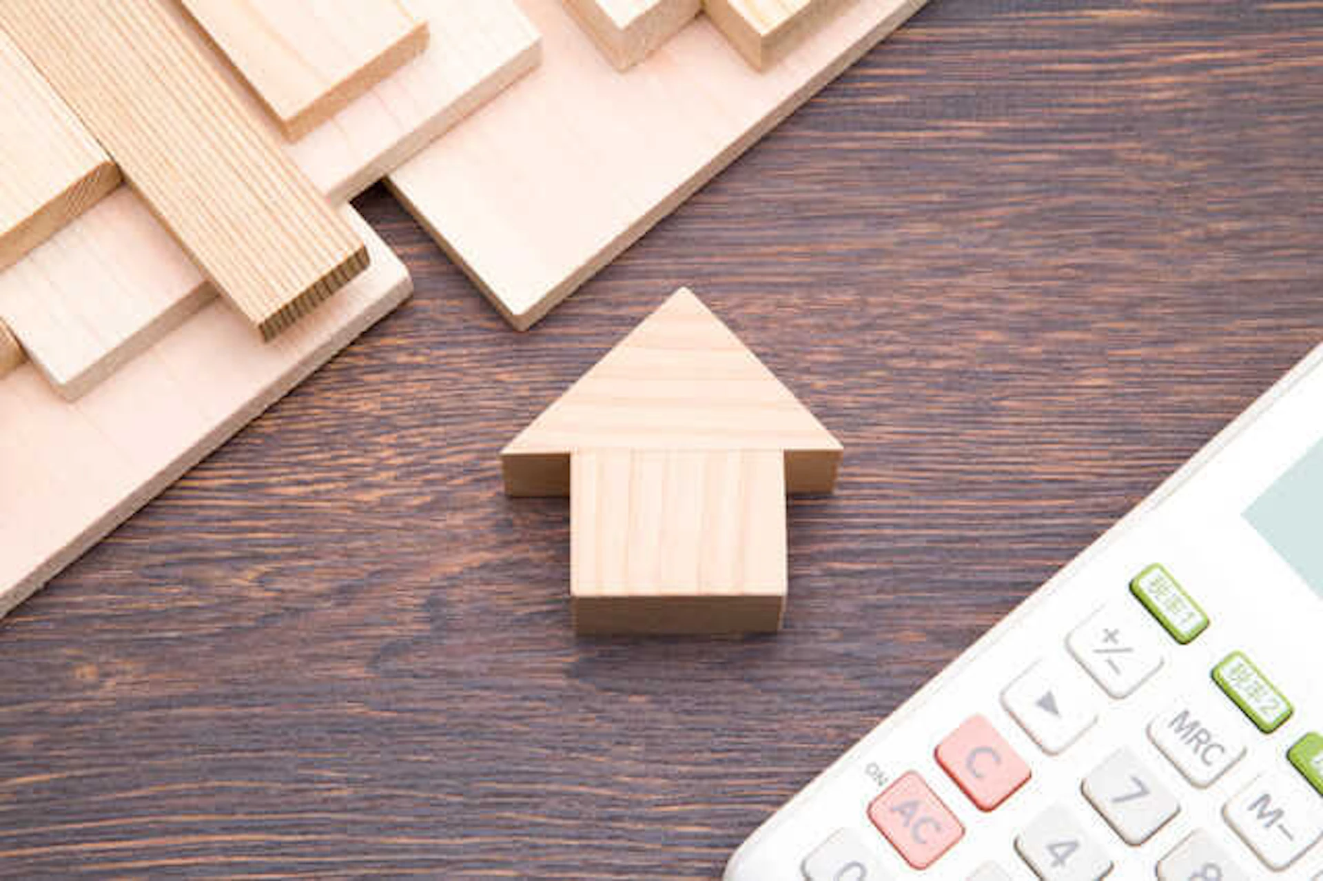 木製の矢印模型と電卓