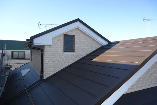 ベージュのガルバリウム鋼板の外壁と黒い屋根