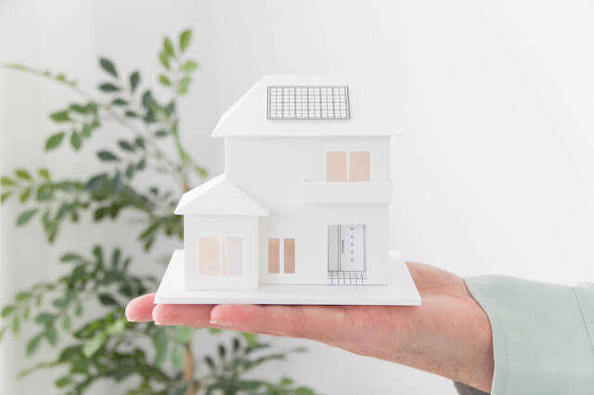 住宅の形のオブジェを掲げた手