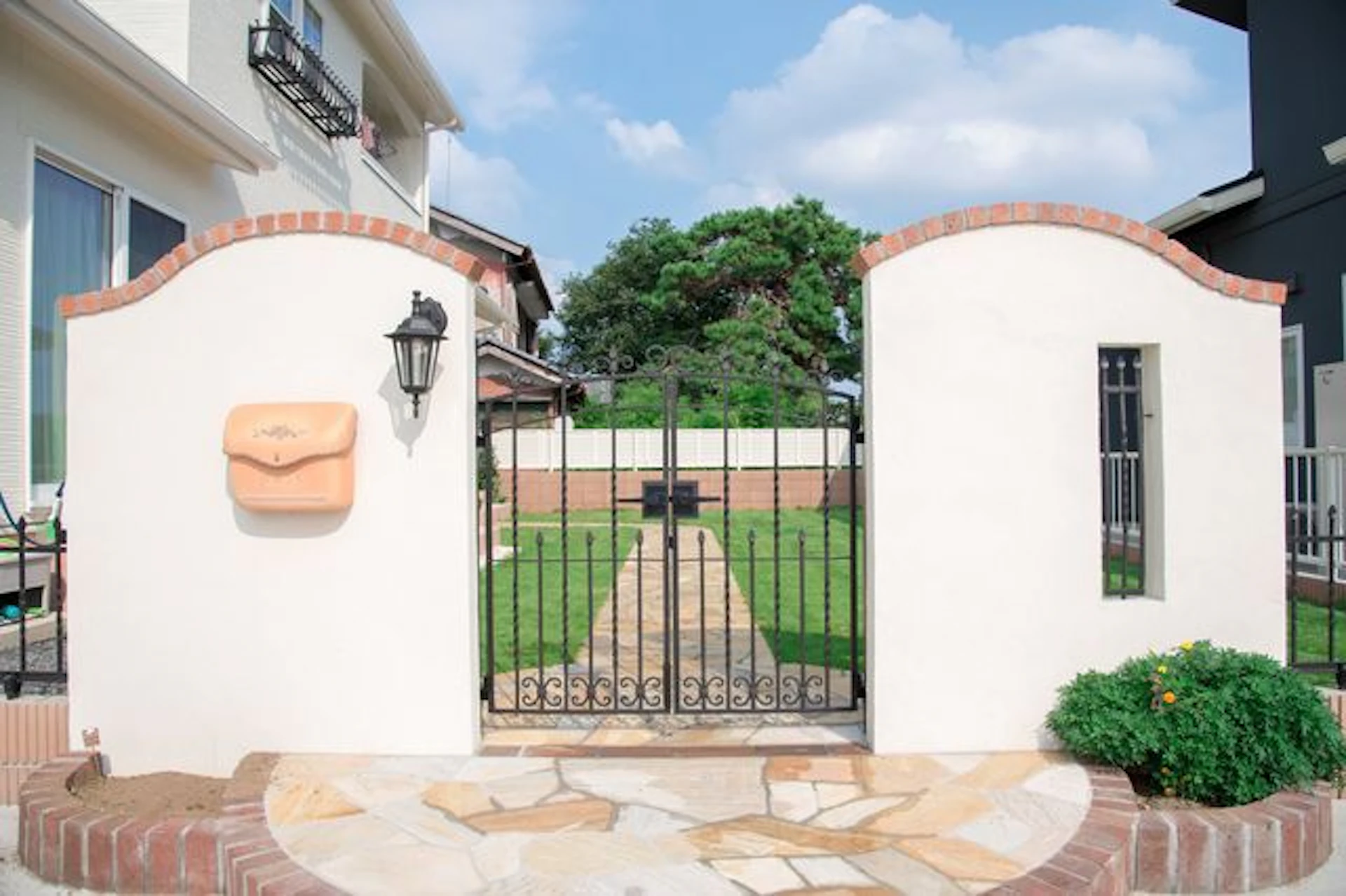 黒い門扉があり白とレンガを基調とした北欧風デザインの門