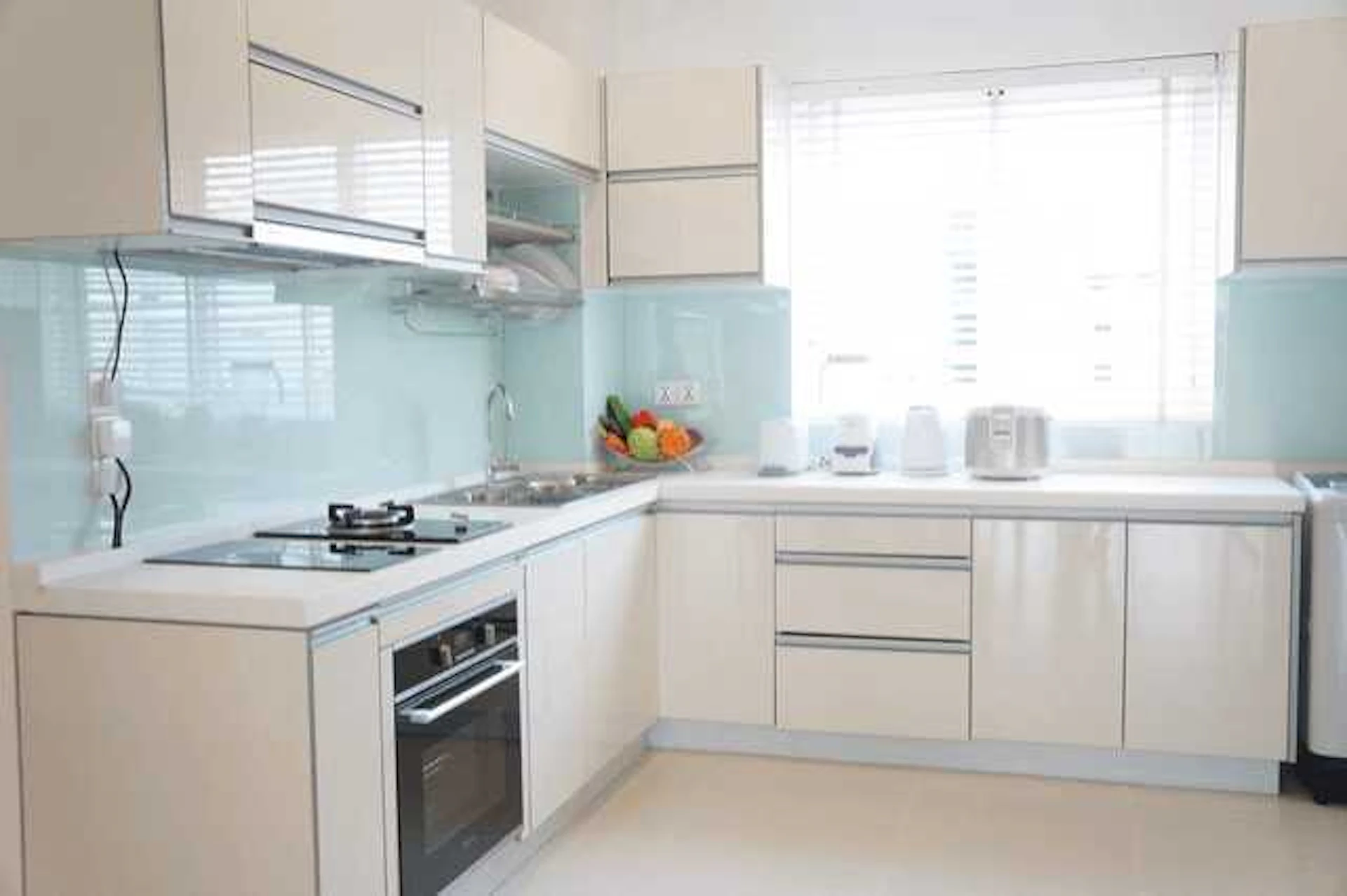 白と水色で構成されているL型キッチンの写真