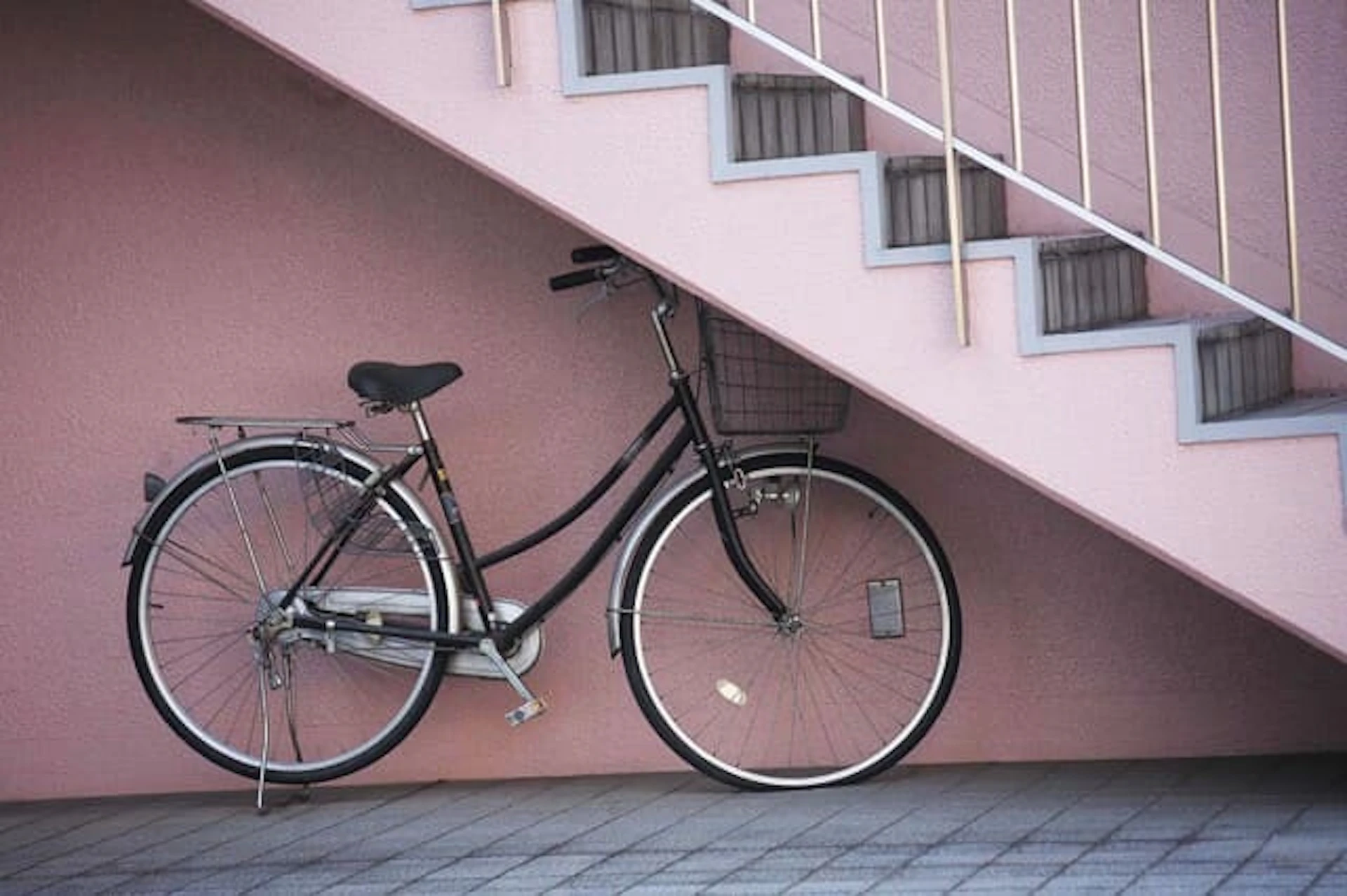 外階段の下に置かれたシルバーの自転車