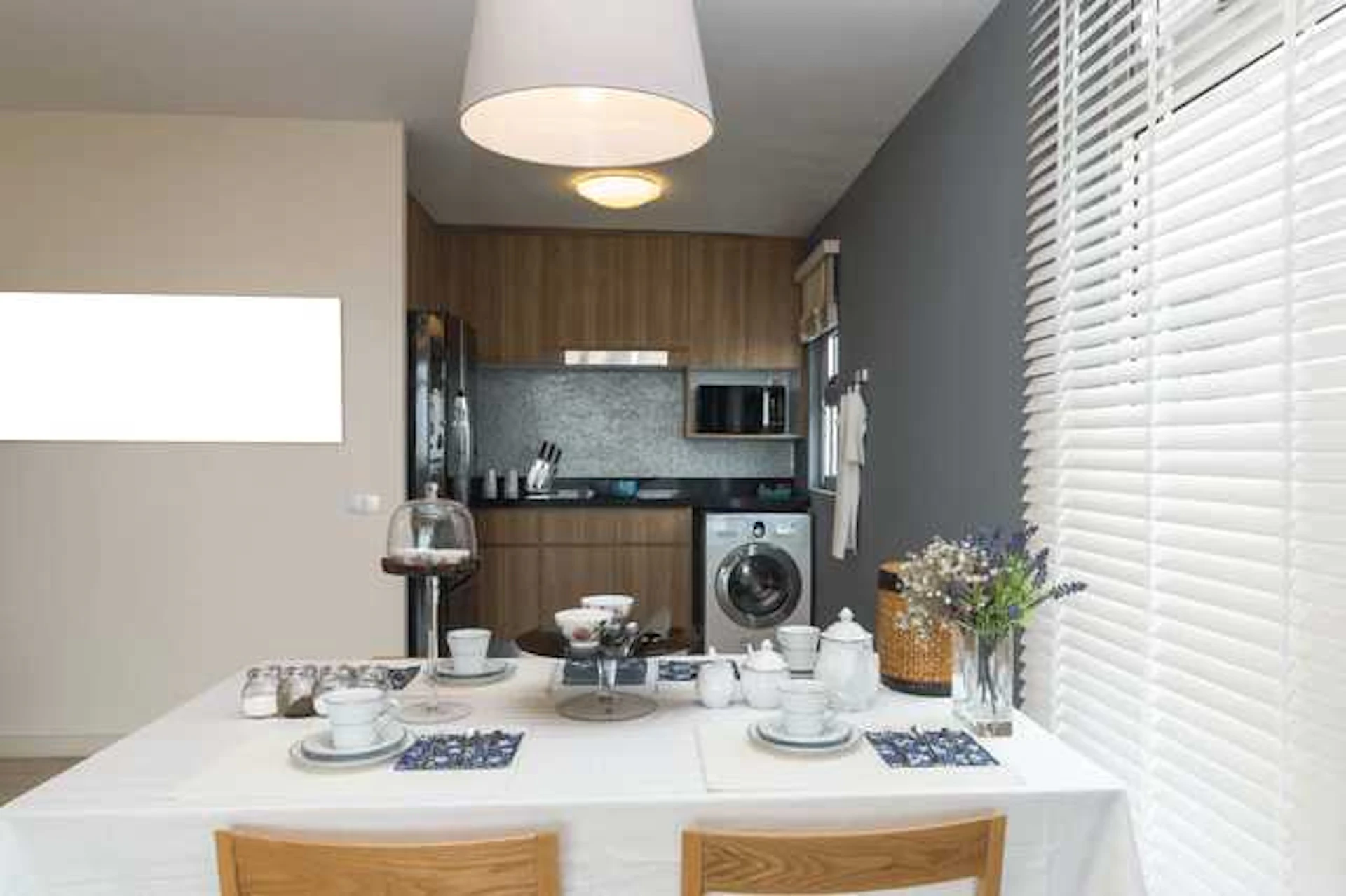 白いシーリングランプと木目調のキッチンが特徴のダイニング