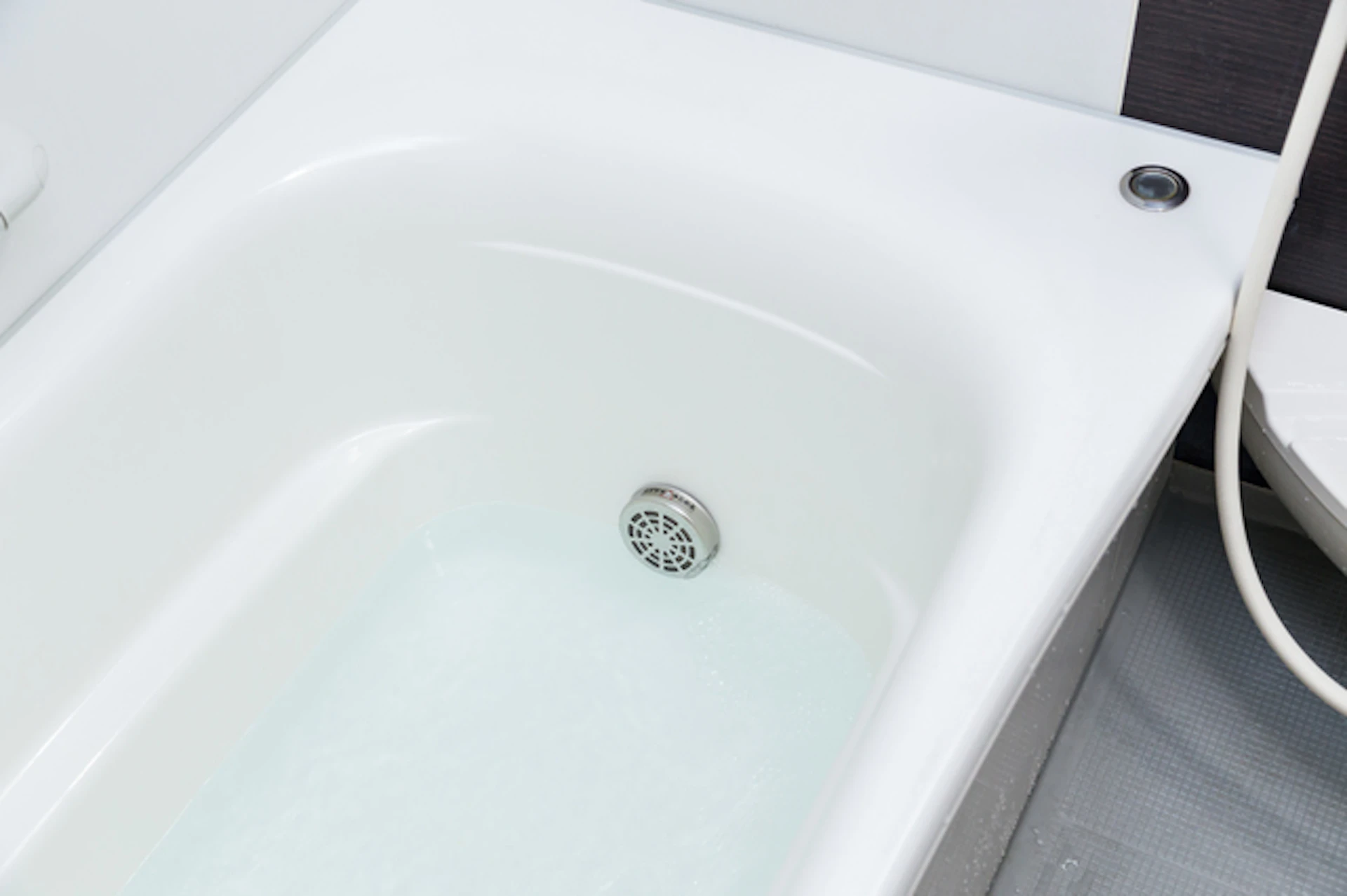 僅かに水が入っている白い浴槽