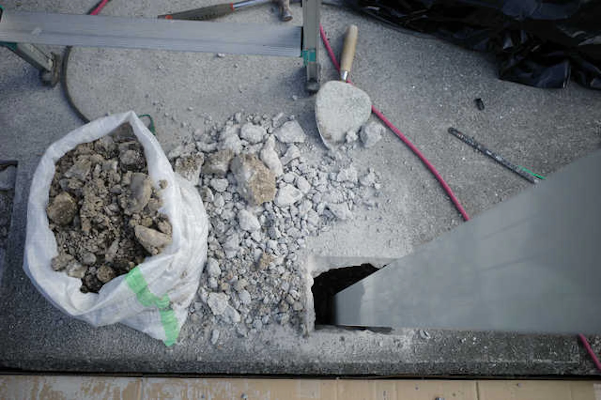 穴の開いた道路にある礫岩が詰まっている袋