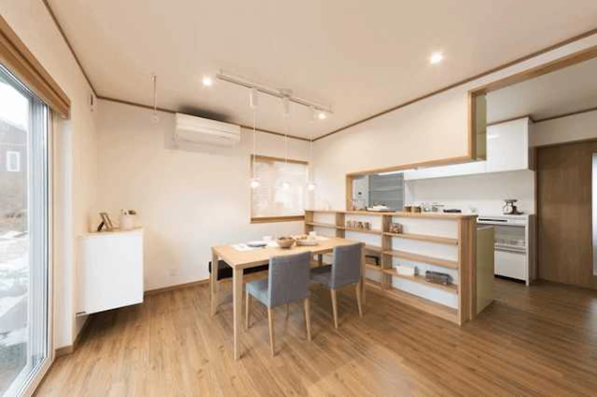 白い壁を基調としたダイニング、ダイニングテーブルセットが置かれている