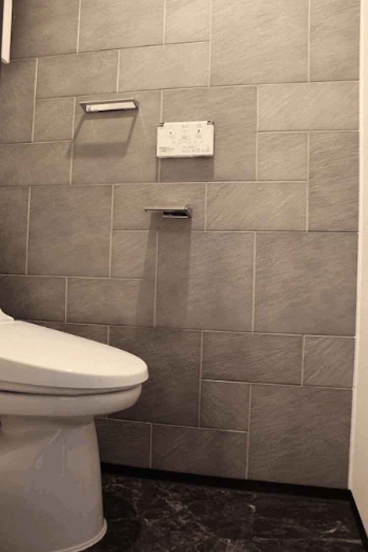 壁材にリクシル社のエコカラット、床材に大理石調のクッションフロアを採用したトイレリフォーム