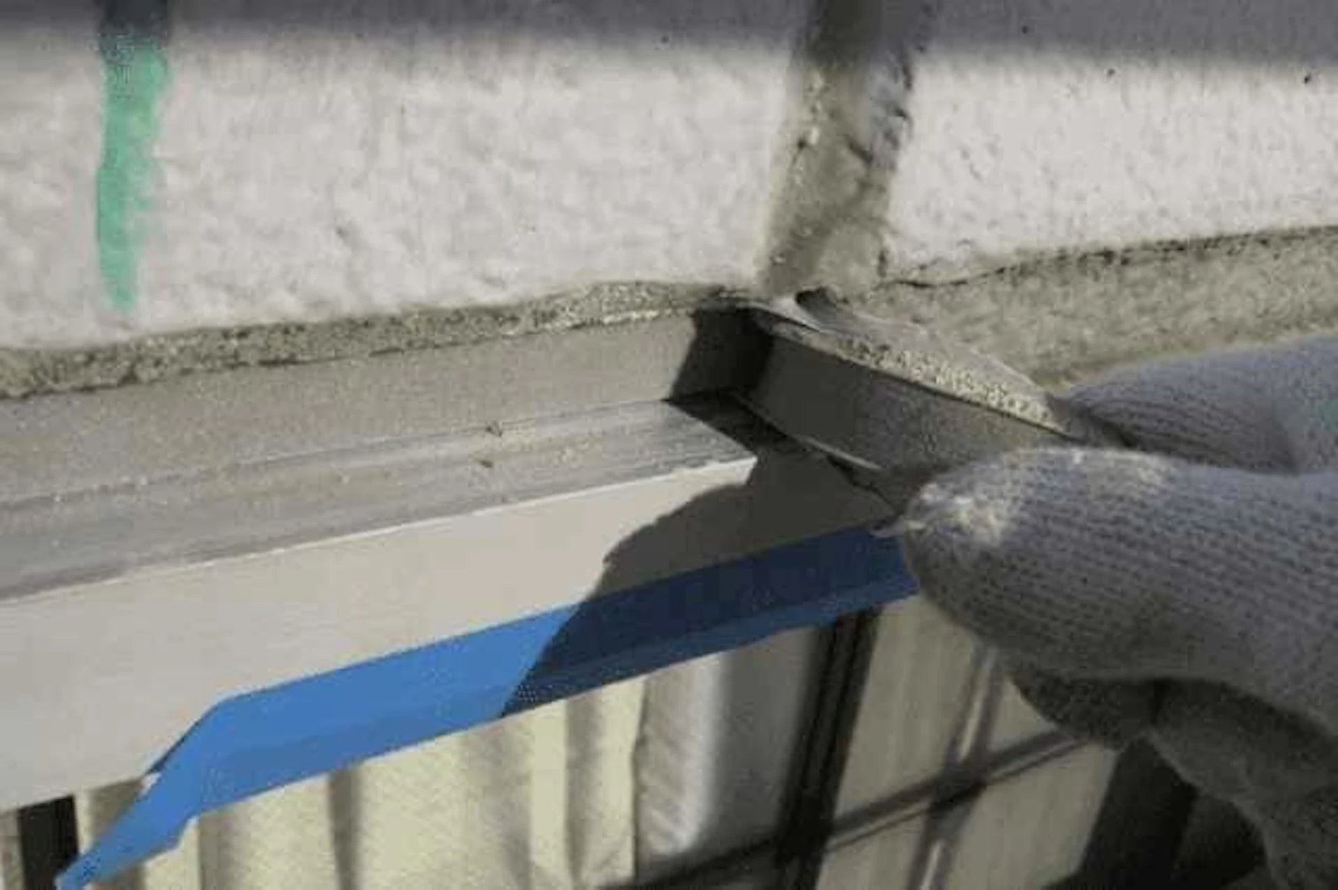 外壁のコーキング修理を進める男性作業員の手元