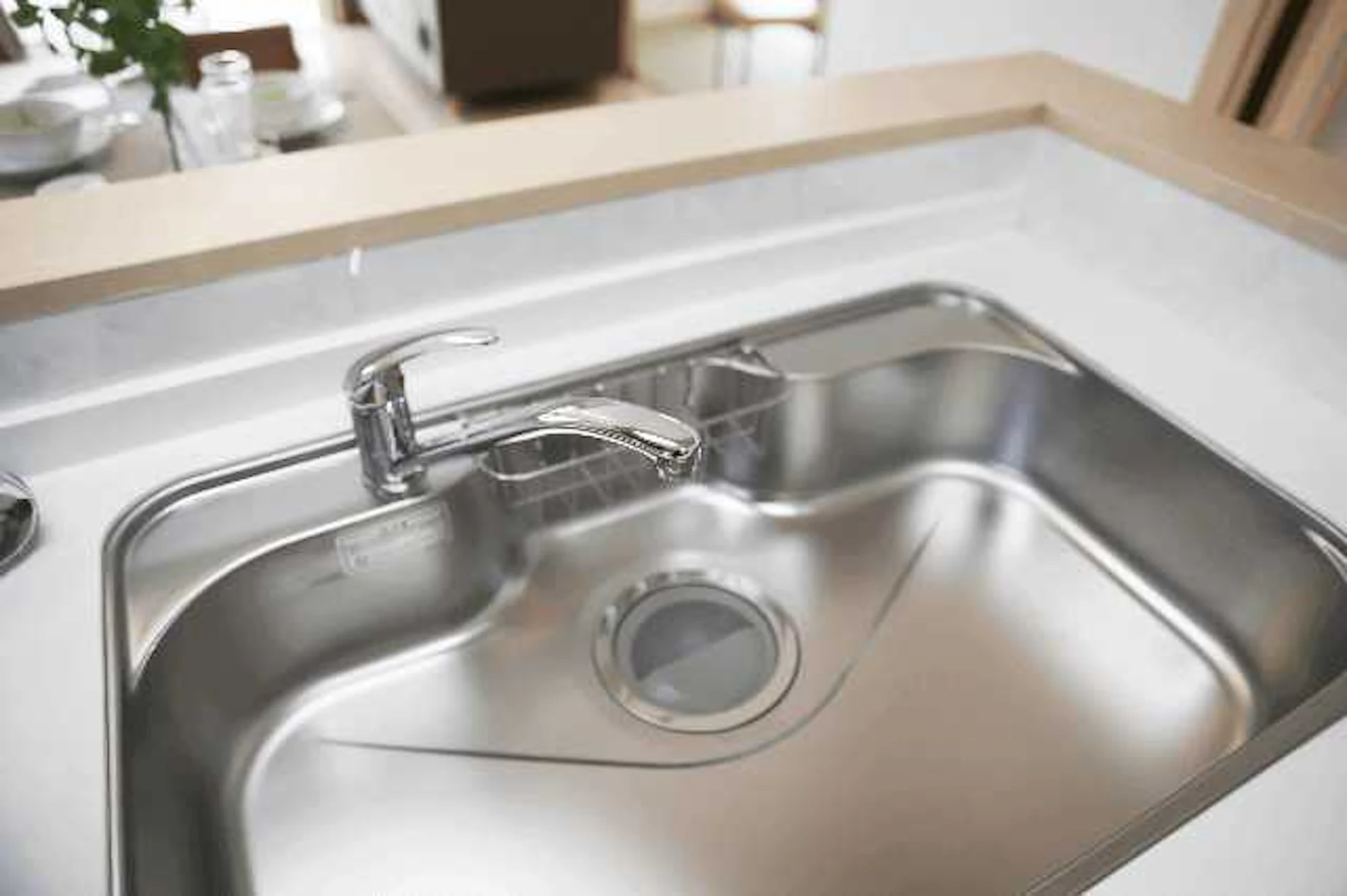 木で縁取られたL型キッチンのシンクの写真