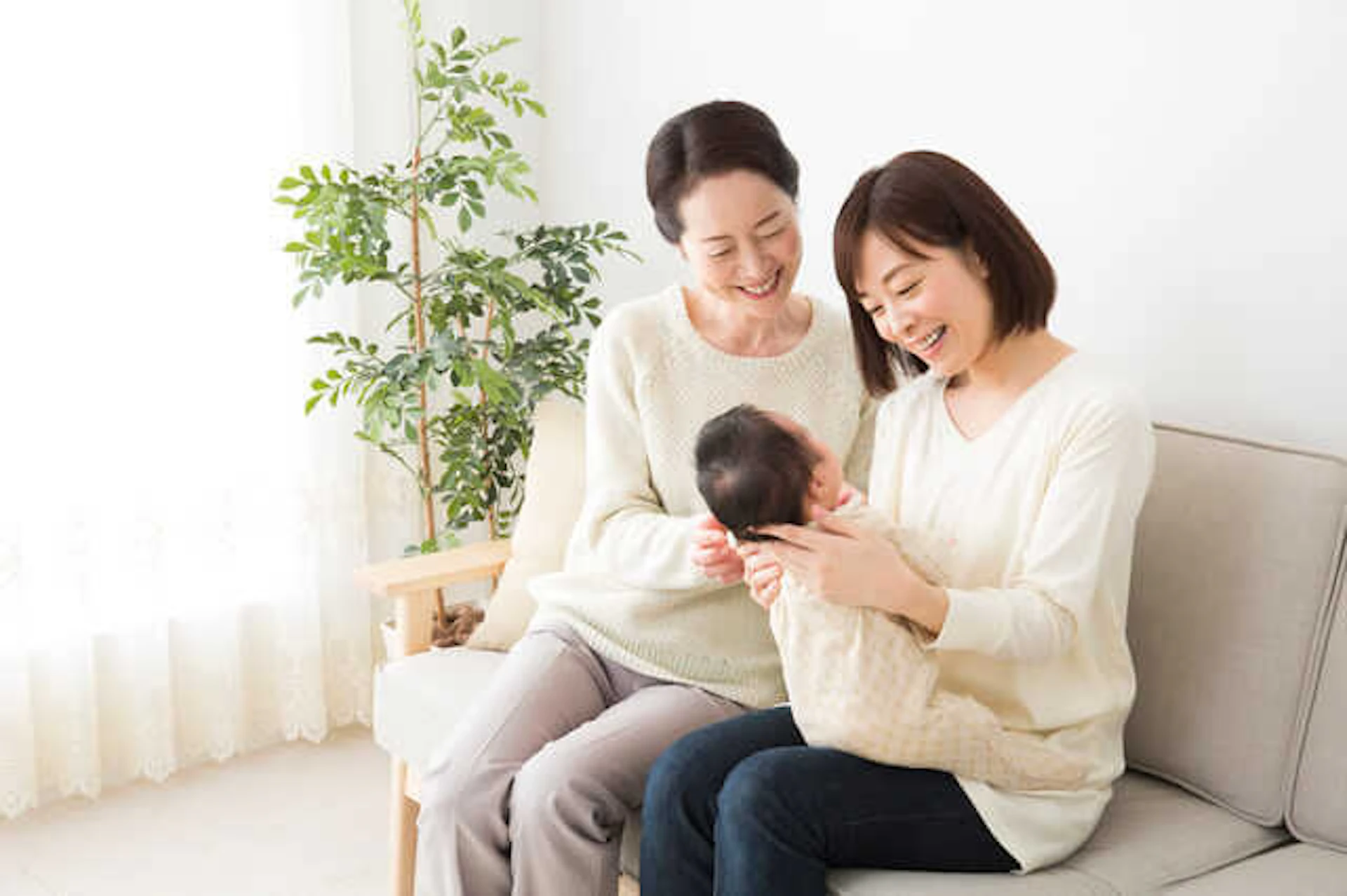 ソファに座る親子、赤ちゃんを膝にのせている